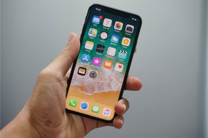 Una persona sosteniendo un iPhone con un antivirus instalado.